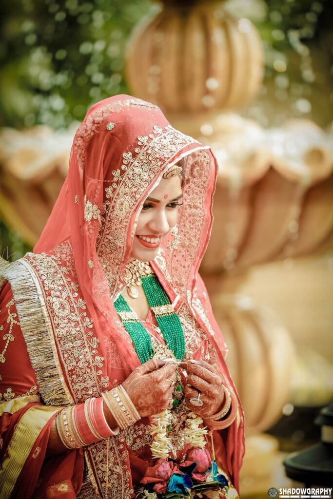 A bride in a pink lehenga photographed outdoors in daylight