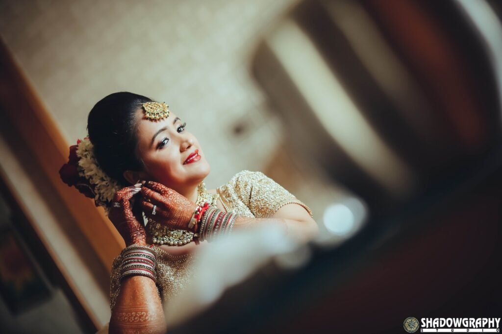 Bride getting ready beside a window in soft early morning light