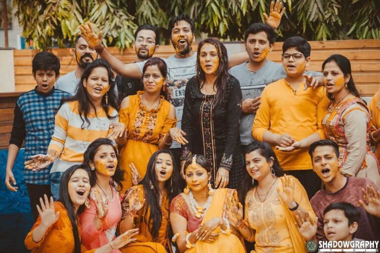 Family in yellow outfits celebrating an outdoor haldi ceremony in daylight