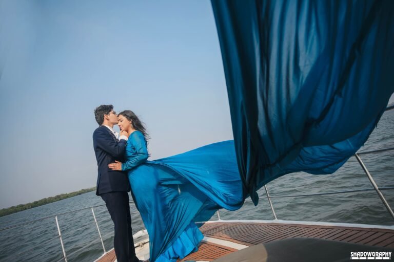 Couple on a boat deck during a pre-wedding shoot, the bride in a flowing blue gown
