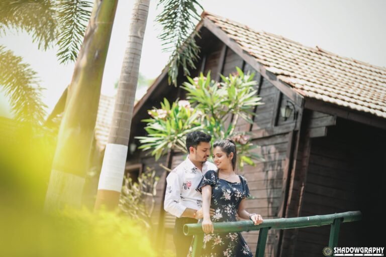 Couple standing beside a wooden hut surrounded by palm trees during a garden pre-wedding shoot