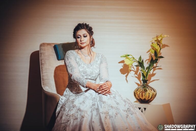 Bride in an elegant white gown seated for a portrait in her reception look