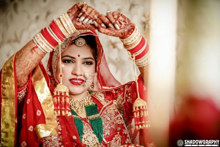 Bride in a red lehenga adjusting her dupatta during wedding day preparations