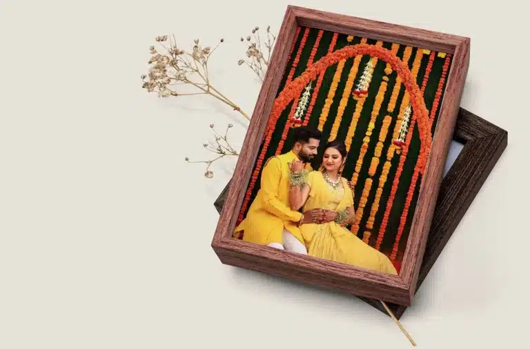 A wedding album with a couple photo cover resting in a wooden keepsake box with dried flowers