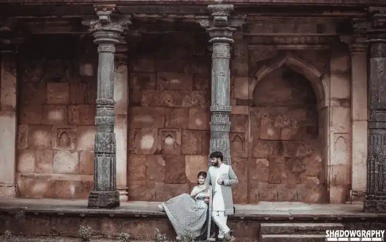 Couple beside stone pillars at Mandu