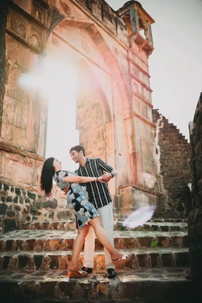 Couple beneath a sunlit arch at Mandu