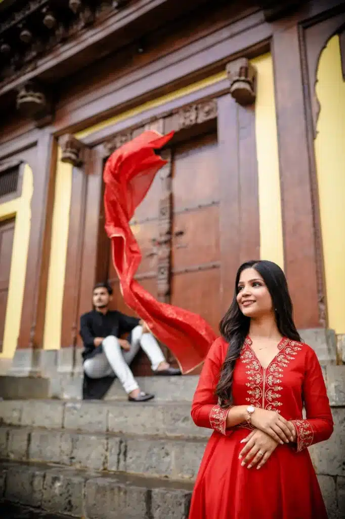 Couple posing with a red dupatta at Rajwada