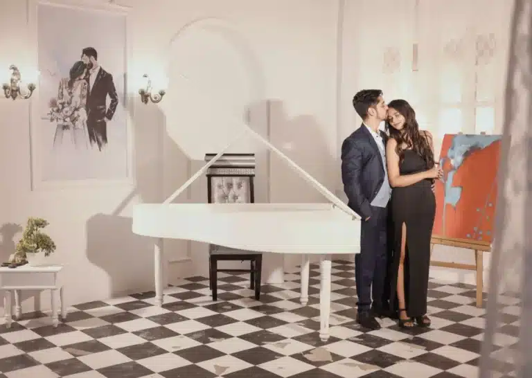 Couple beside a white piano at a Film City setup