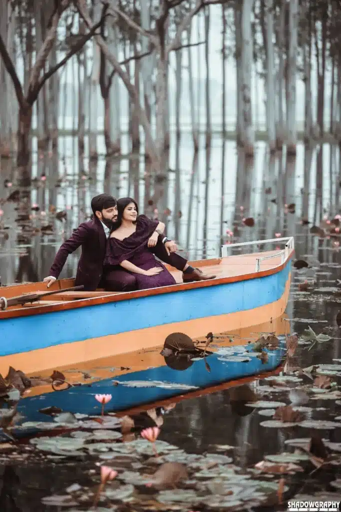 Couple in maroon outfits seated in a boat at Lotus Valley Gulawat